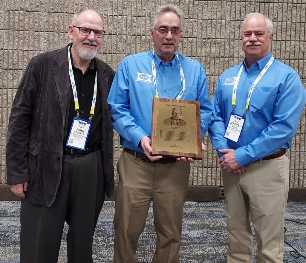 Photo of Henry's sons, Kevin and Jeff Kuhl, accepting the award in his honor, pictured with John Starkey.